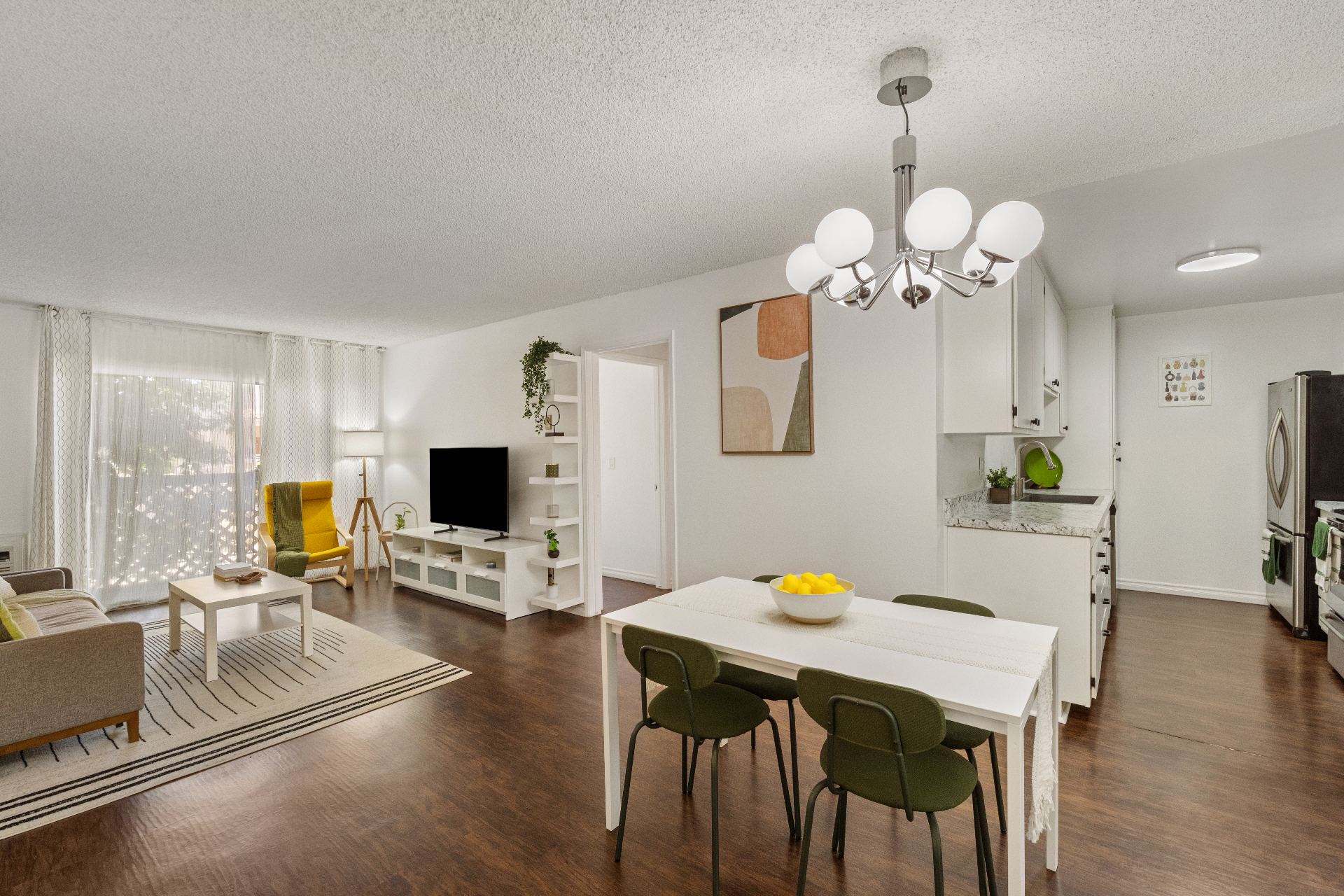 Open living and dining area with chandelier and laminate flooring